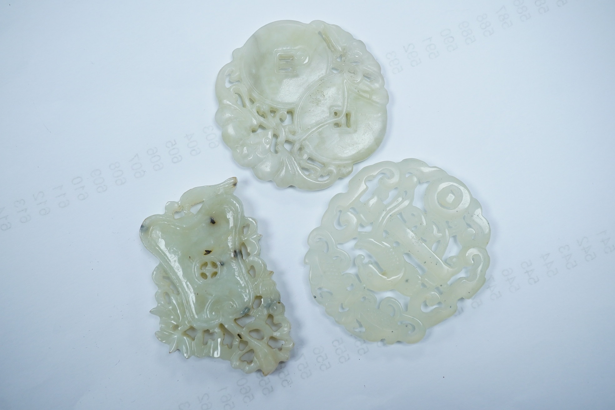 Three Chinese jade or jadeite carved plaques, two circular, largest 5cm. Condition - good